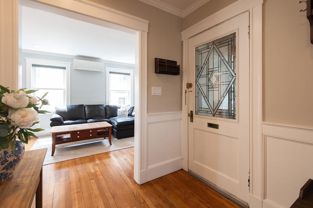 105 Fletcher St Unit 1, Boston, MA 02131 - entrance foyer with a wall mounted air conditioner, light wood-style flooring, ornamental molding, a decorative wall, and wainscoting