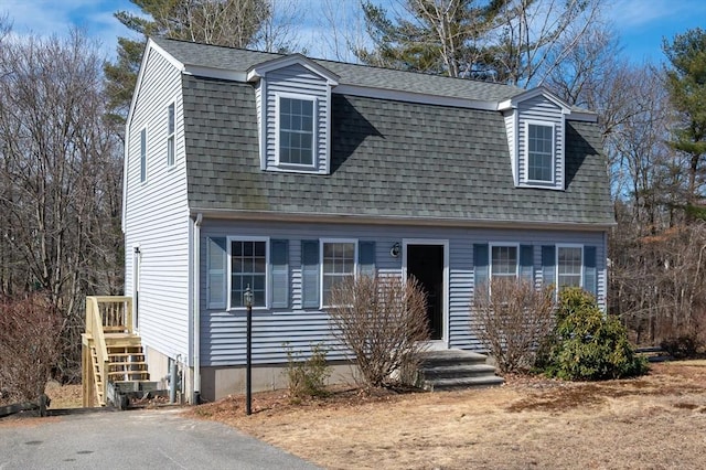 dutch colonial with a gambrel roof and roof with shingles