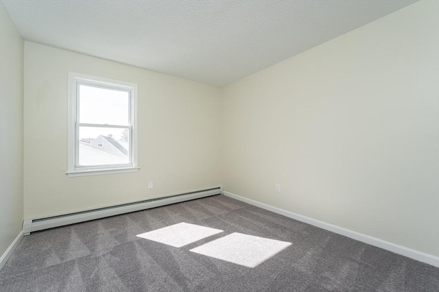 spare room featuring a textured ceiling, baseboards, a baseboard heating unit, and carpet