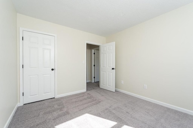 unfurnished bedroom with baseboards, carpet, and a textured ceiling