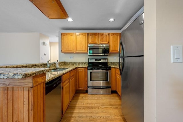 14 Midgley Ln, Worcester, MA 01604 - kitchen featuring appliances with stainless steel finishes, dark stone countertops, light wood-style flooring, a peninsula, and brown cabinets