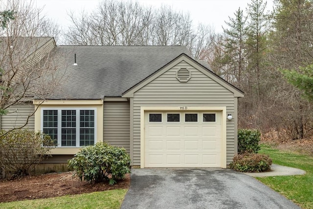 view of front of house with driveway, a shingled roof, and a garage