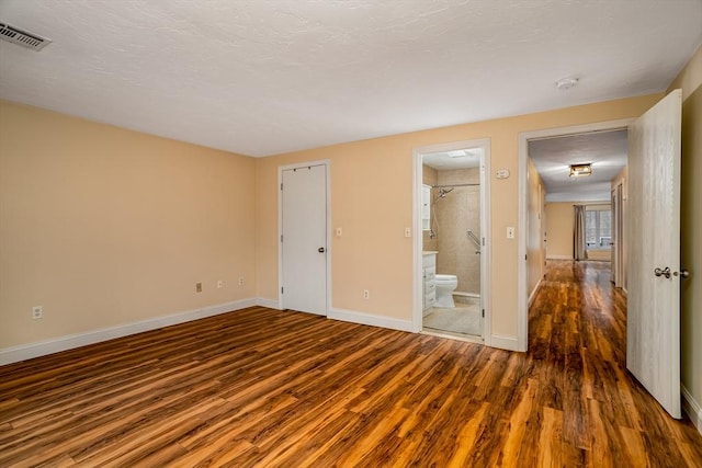 empty room with visible vents, baseboards, and wood finished floors