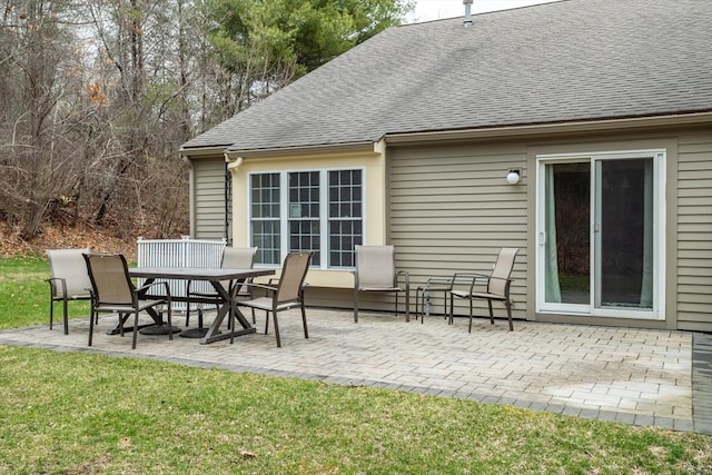 back of property with a lawn, a patio area, a shingled roof, and outdoor dining area