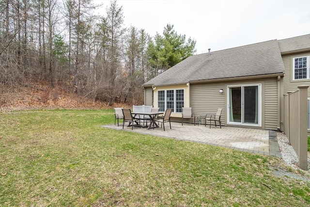 rear view of property with a patio area, a lawn, and a shingled roof
