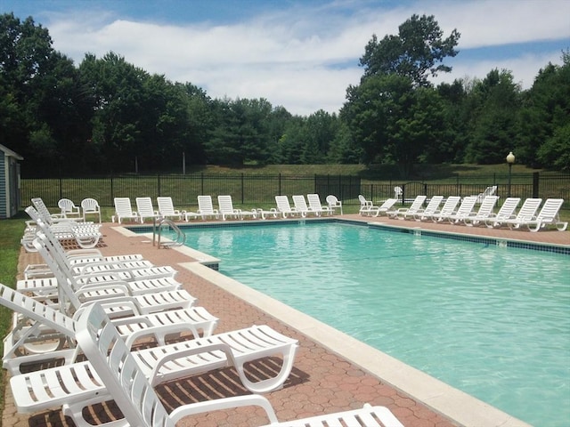 pool featuring fence and a patio
