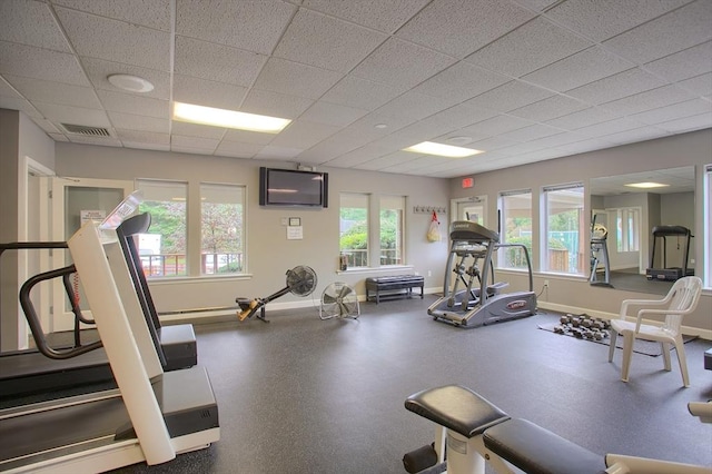 workout area with baseboards, visible vents, and a paneled ceiling