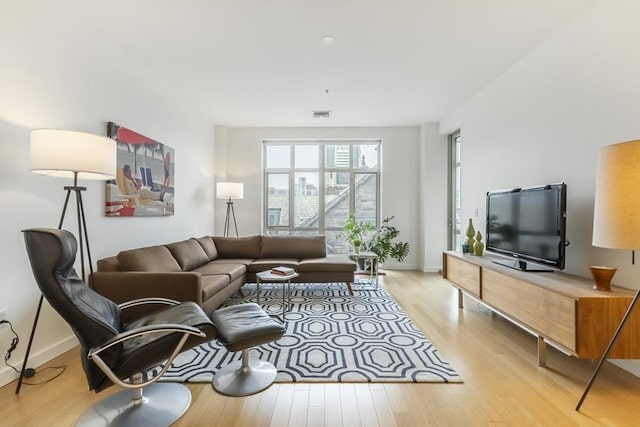 living area featuring light wood-style flooring and baseboards