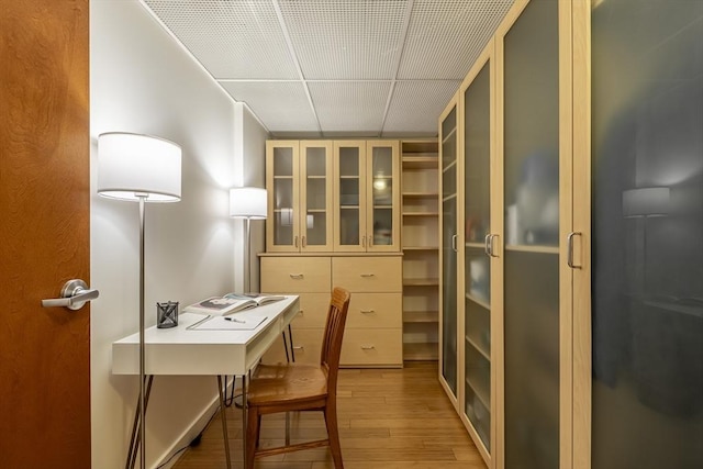 office space with light wood finished floors and a drop ceiling