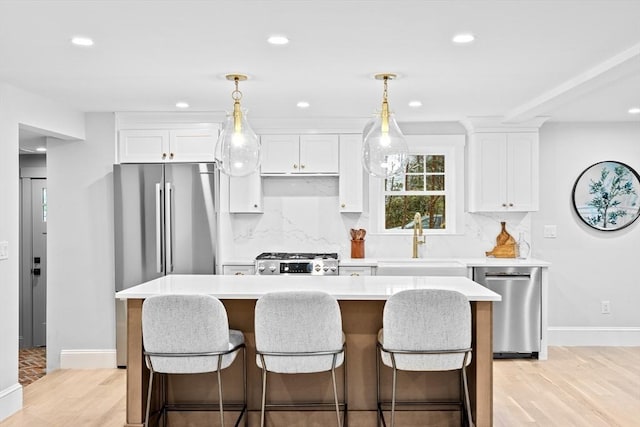 kitchen with a kitchen island, sink, white cabinetry, and stainless steel appliances