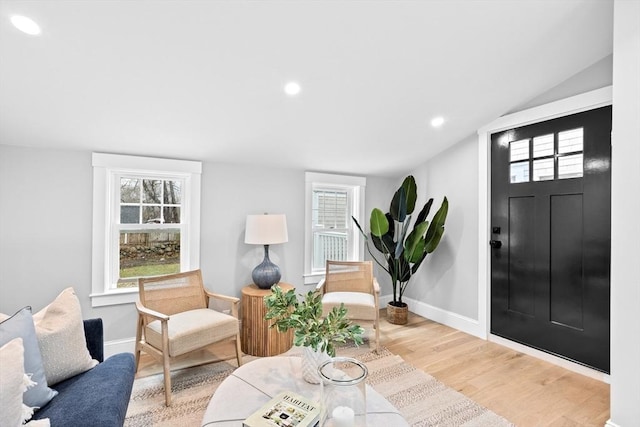 sitting room with light wood-type flooring and lofted ceiling