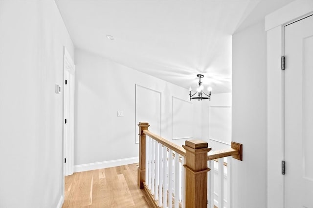 hallway featuring a chandelier and light hardwood / wood-style flooring