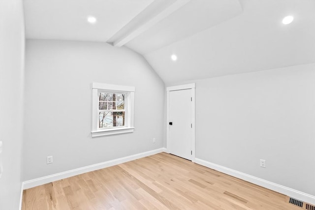 additional living space with vaulted ceiling with beams and light hardwood / wood-style flooring