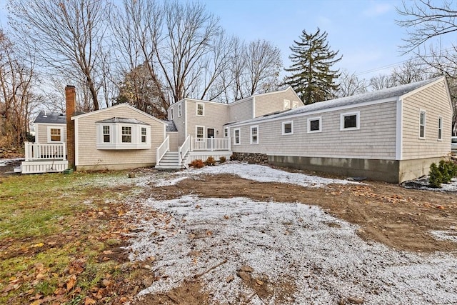 rear view of property featuring a wooden deck