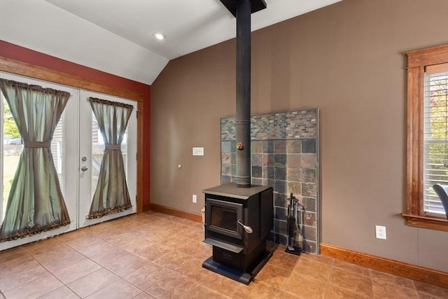 40 George St, Attleboro, MA 02703 - living room with a wood stove, lofted ceiling, baseboards, light tile patterned floors, and french doors