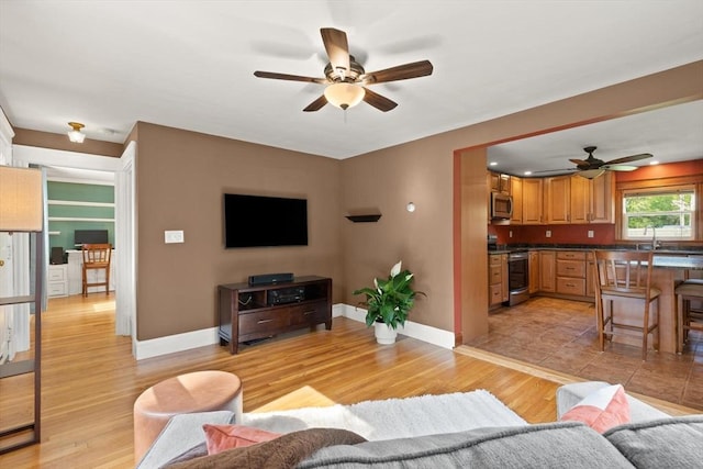 40 George St, Attleboro, MA 02703 - living room featuring a ceiling fan, light wood finished floors, and baseboards