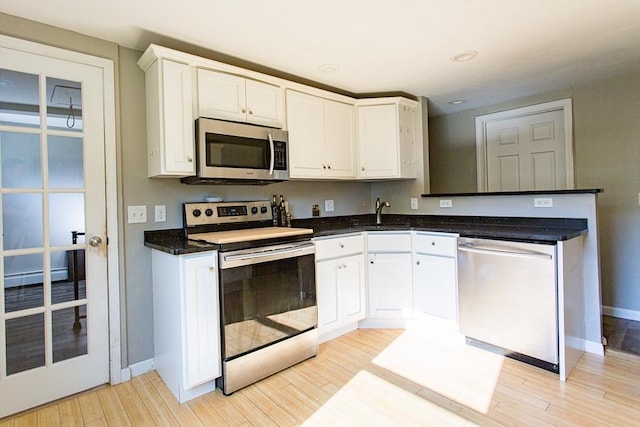 76 Kennedy Rd, West Brookfield, MA 01585 - kitchen with appliances with stainless steel finishes, a sink, light wood-type flooring, baseboards, and white cabinets