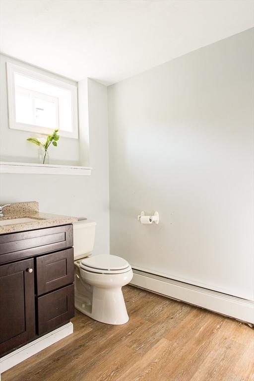 76 Kennedy Rd, West Brookfield, MA 01585 - bathroom featuring a baseboard heating unit, toilet, wood finished floors, and vanity