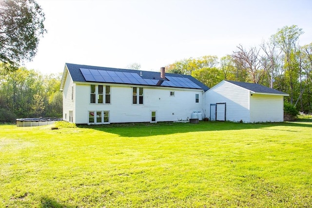 76 Kennedy Rd, West Brookfield, MA 01585 - back of property with roof mounted solar panels, a chimney, a yard, and an outdoor pool