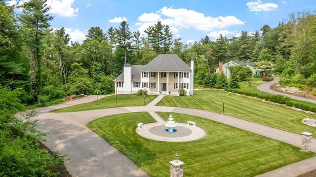69 Carter Dr, Framingham, MA 01701 - view of front of home with curved driveway, a front yard, and a chimney