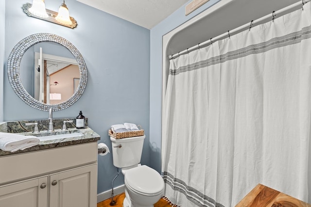 bathroom featuring toilet, vanity, and hardwood / wood-style floors