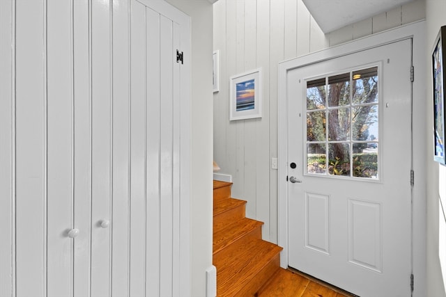 doorway featuring wood walls and hardwood / wood-style flooring