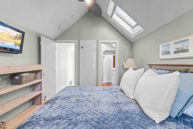 bedroom featuring vaulted ceiling with skylight and ensuite bathroom