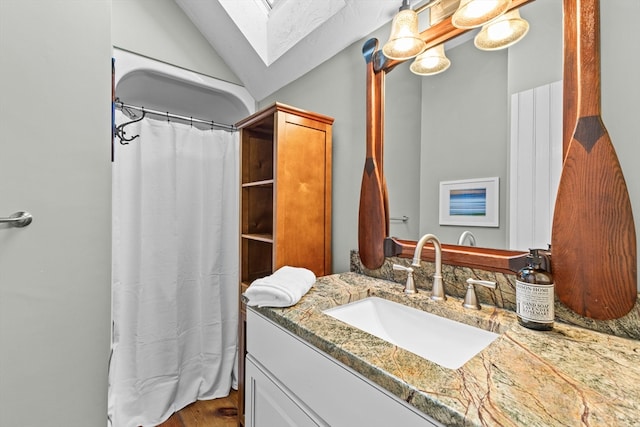 bathroom with vanity and lofted ceiling with skylight