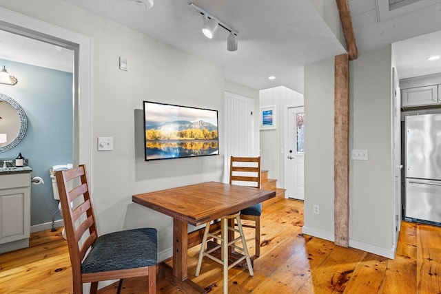 dining area featuring rail lighting and light wood-type flooring