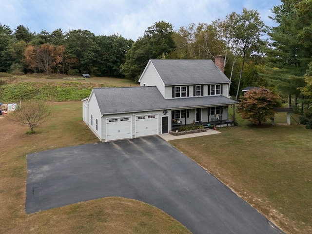 colonial inspired home featuring a front yard, a garage, and a porch