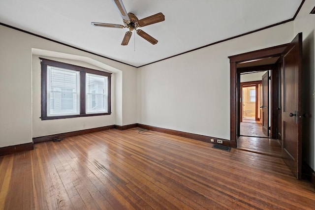 empty room featuring wood-type flooring, a ceiling fan, ornamental molding, and baseboards