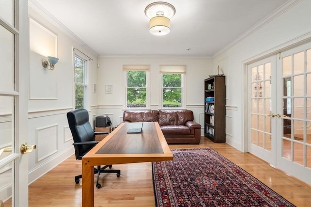 office space featuring ornamental molding, french doors, light wood finished floors, and a decorative wall