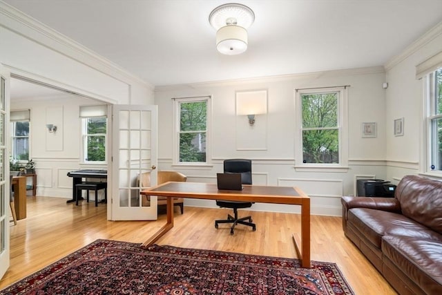 home office featuring ornamental molding, french doors, light wood finished floors, and a decorative wall