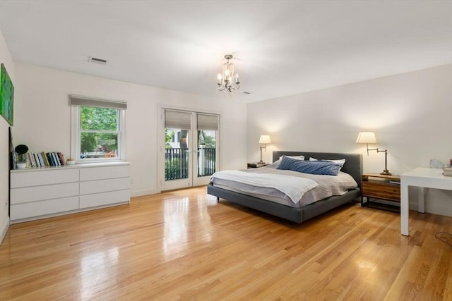 bedroom with light wood-type flooring, access to outside, a chandelier, and visible vents