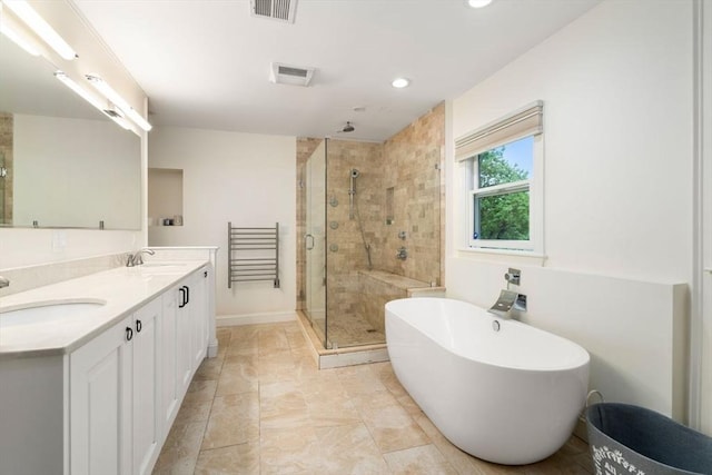 full bathroom featuring a freestanding tub, a shower stall, visible vents, and a sink