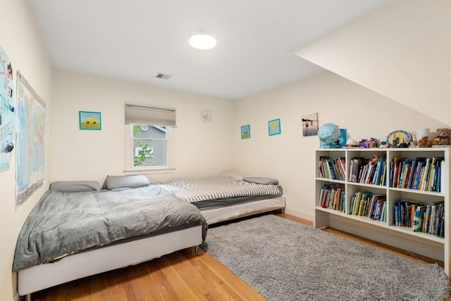 bedroom with visible vents and wood finished floors