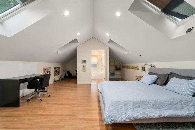 bedroom featuring lofted ceiling with skylight, recessed lighting, connected bathroom, and light wood finished floors