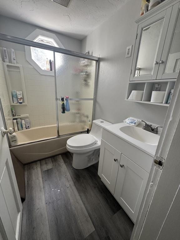 13 Coombs St, Southbridge, MA 01550 - full bath featuring vanity, wood finished floors, toilet, and shower / bath combination with glass door