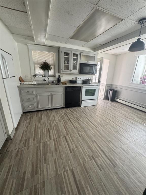 13 Coombs St, Southbridge, MA 01550 - kitchen with a baseboard heating unit, a sink, glass insert cabinets, black appliances, and gray cabinetry