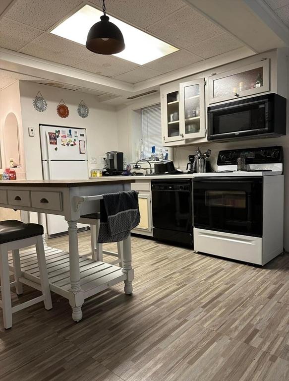 13 Coombs St, Southbridge, MA 01550 - kitchen featuring white cabinetry, black appliances, light wood-style floors, and glass insert cabinets