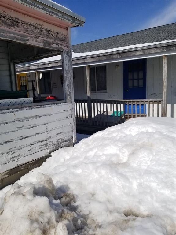 view of home's exterior featuring a porch and roof with shingles