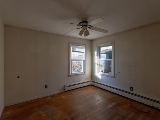 empty room featuring ceiling fan, wood-type flooring, and a baseboard heating unit