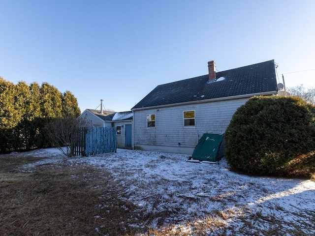 view of snow covered back of property