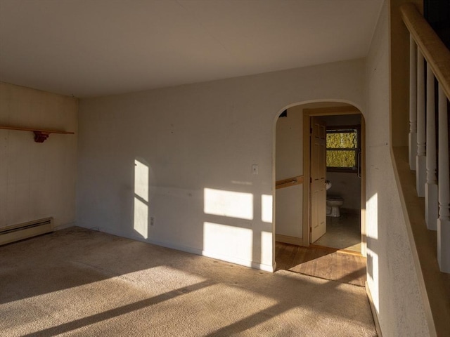 unfurnished room with light colored carpet and a baseboard radiator