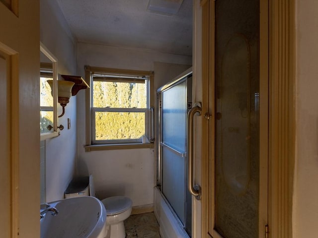 full bathroom featuring combined bath / shower with glass door, toilet, and sink