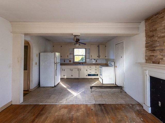 kitchen with white appliances, backsplash, white cabinets, sink, and wood-type flooring