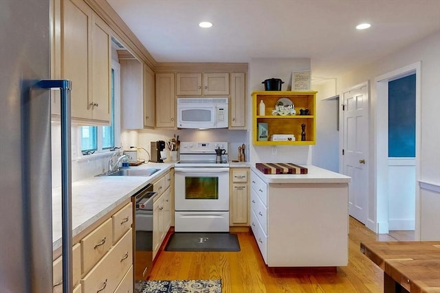 kitchen with a sink, white appliances, light wood-style flooring, and light countertops