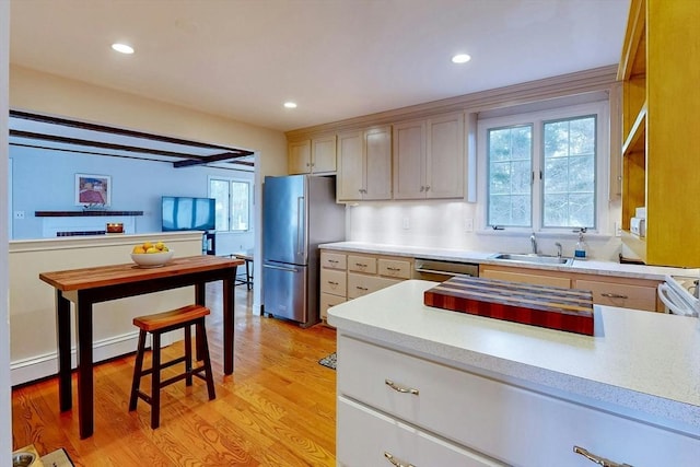 kitchen featuring recessed lighting, a sink, stainless steel appliances, light countertops, and light wood-style floors