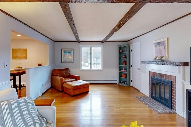 living room featuring a baseboard heating unit, beam ceiling, a brick fireplace, and light wood finished floors