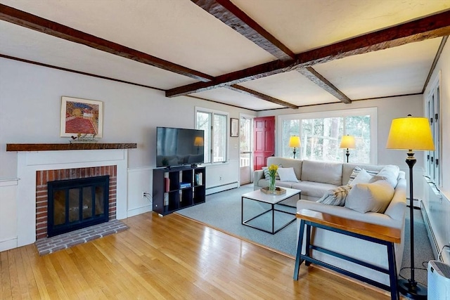 living room with beam ceiling, hardwood / wood-style flooring, a baseboard heating unit, a fireplace, and baseboard heating